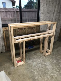 a wooden bench sitting in front of a window