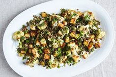 a white plate topped with broccoli and cauliflower