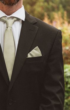 a man wearing a suit and tie with his hands in his pockets