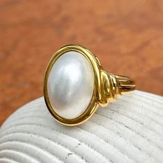 New, but old pieces, never worn, recently acquired from a premier jeweler located in Minneapolis, MN for many years- a rare opportunity! 18KT yellow Ggld genuine, bezel-set, white, oval, mabe pearl ring. Size 6.75 Sizable by us for a fee or your local jeweler Weight: 10.3 grams Band width: 3mm in back Pearl measures: 15mm x 11mm oval mabe pearl Stamped 18k By Honora Elegant White Domed Jewelry, Timeless Oval Rings With High Luster, White Domed Jewelry For Anniversary, Heirloom High Luster Oval Pearl Ring, Classic Cabochon Pearl Ring For Formal Occasions, Classic Formal Pearl Ring With Cabochon, Anniversary Yellow Gold Pearl Ring With Cabochon, Luxury High Luster Oval Pearl Ring, Luxury Oval Pearl Ring With Polished Finish