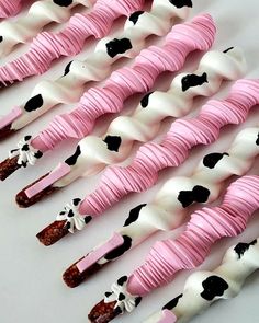 there are many pink and white marshmallows in the shape of cows with black spots on them