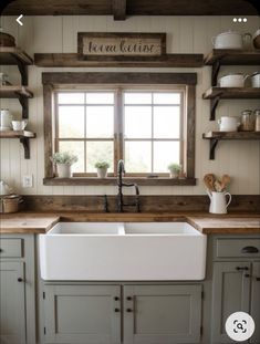 a white kitchen sink sitting under a window