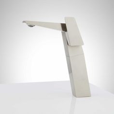 the modern sink is made out of white marble and has an angled faucet