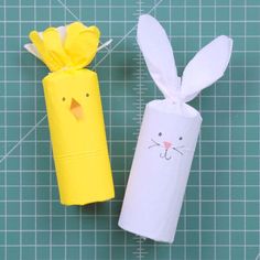 two toilet paper rolls with bunny and cat faces on them, one is yellow and the other is white