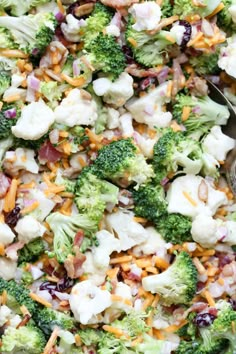 a salad with broccoli, cauliflower and cranberries in it