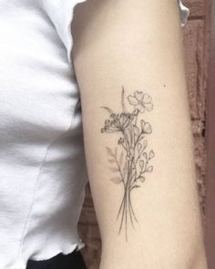 a woman's arm with a flower tattoo on the left side of her arm