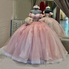 two mannequins dressed in pink gowns and flower bouquets on display