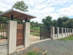 the gate is made of concrete and has a wooden paneled door on one side