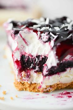 a piece of cheesecake with blueberries and whipped cream on top is sitting on a white plate