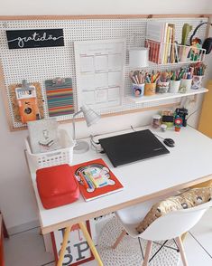 a white desk topped with a laptop computer next to a shelf filled with office supplies