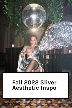 a woman sitting on top of a chair next to a disco ball