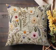 an embroidered pillow with flowers on it