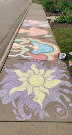 the sidewalk is decorated with colorful chalk and has an image of a sunflower on it