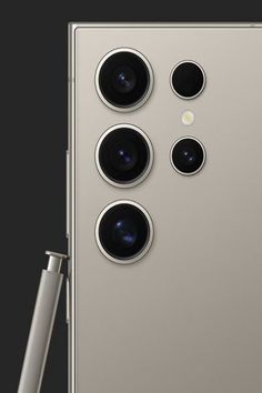 the back side of a silver cell phone with three cameras on it and one camera attached to