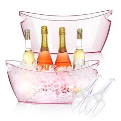 three bottles of champagne in ice buckets with tongs and utensils on white background