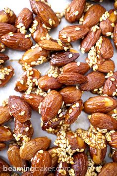 almonds with sesame seeds on a white surface