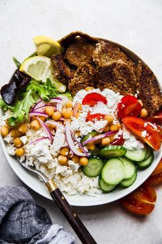 a white plate topped with meat, rice and veggies