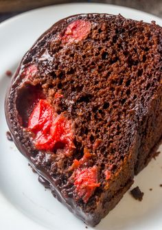 a piece of chocolate cake with strawberries on top is sitting on a white plate