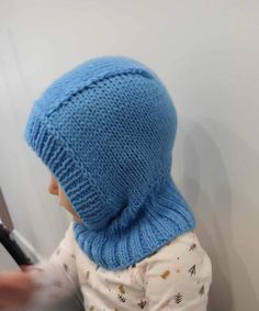 a small child wearing a blue knitted hat