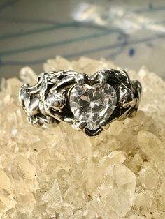 "Cupid ring size 8.25 holding heart love Valentine stone figurative sterling silver women  Size 8.25 Weight. 5.3g Length.  3/8\" Widest part  1/2\" Thinnest part  1/8\"  Free Shipping & Free Postal Insurance   Delivered in a Gift Box   If you do not want the ring polished and want to leave the natural patina please let me know at the time of purchase as I do polish rings before I ship rings out. Thanks  Free First Class shipping and postal insurance is included. If you want to upgrade to priority kindly pay an additional fee to do so.  This is recommended if you would like to have your package delivered faster than first class which has slowed down due o a variety of factors" Silver Crystal Promise Ring For Valentine's Day, Heart-cut Sterling Silver Crystal Ring, Sterling Silver Heart Promise Ring, Vintage Sterling Silver Heart Promise Ring, Symbolic Heart-shaped Rings For Anniversary, Silver Heart Ring With Vvs Clarity For Valentine's Day, Valentine's Day Sterling Silver Crystal Ring, Valentine's Day Sterling Silver Rings With Center Stone, Valentine's Day Silver Crystal Gemstone Ring