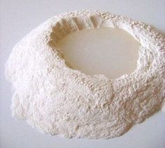 a white bowl filled with flour sitting on top of a table