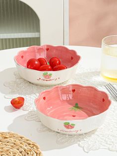 two bowls with tomatoes in them sitting on a table