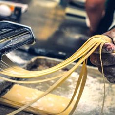 a person is holding some noodles in their hand and they are making something out of them