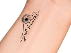 a dandelion tattoo on the wrist reads, just breathe