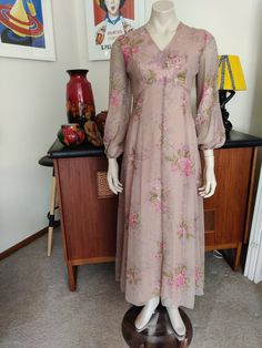 This is a sweet poly chiffon maxi length dress from the era of formal dinner dances and hostess dinners to impress the boss.  The dress is by En- Ka in an unusual colour of a musky pink with rose pink roses and green leaves. The dress has a v neck, empire line high waist and fitted thru the waist and flared at the hips to around ankle length. The dress is lined in rayon acetate except for the sheer sleeves. The condition is very good. Best fit 10 to 12 au Measurements are Shoulder to shoulder 37 Feminine Fitted Maxi Chiffon Dress, Feminine Fitted Maxi Length Chiffon Dress, Fitted Feminine Maxi-length Chiffon Dress, Fitted Feminine Maxi Length Chiffon Dress, Fitted Vintage Chiffon Summer Dress, Vintage Party Chiffon Dress, Fitted Vintage Chiffon Dress For Party, Fitted Vintage Chiffon Party Dress, Fitted Sheer Maxi Dress For Garden Party