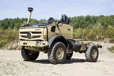 an army truck parked on the side of a dirt road