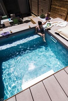 a woman sitting on the edge of a swimming pool