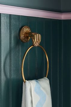 a gold towel ring on the wall in a bathroom