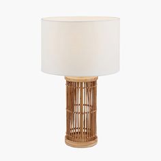 a table lamp with a white shade on the base and a wooden frame around it