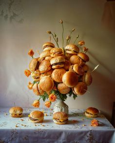 a vase filled with mini sandwiches sitting on top of a table