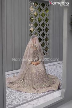 a woman in a wedding dress is sitting on the floor with her veil over her head