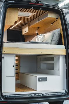 the back end of a van with a bed and drawers in it's cargo area