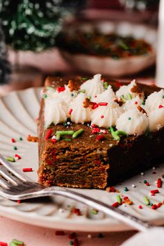 a piece of cake on a white plate with sprinkles and a fork