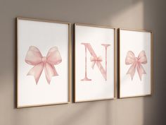 three framed pictures with pink bows hang on the wall