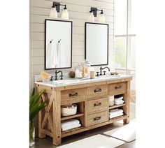 two mirrors are above the double sink vanity in this white and beige bathroom with wood accents