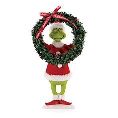 the grinch is holding a wreath in his hands