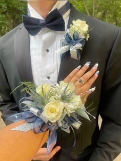 a man in a tuxedo holding a bouquet of flowers with his hands on the woman's lapel