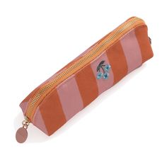 an orange and pink striped pencil case with a blue flower on it's side