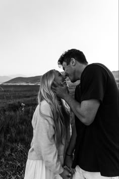 a man and woman kissing in a field