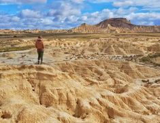 a man standing on top of a sandy hill