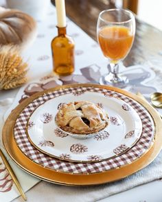 a plate with a pie on it next to a glass of orange juice