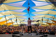 a man standing on top of a stage in front of a large group of people