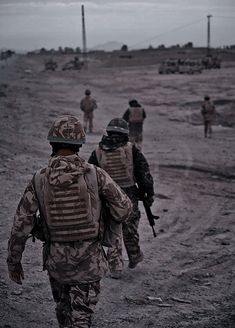 soldiers walking in the sand with their backs turned