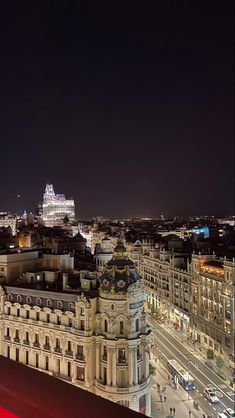 the city is lit up at night with many buildings and lights in the foreground