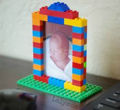 a lego photo frame sitting on top of a desk next to a computer mouse and keyboard