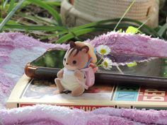 a small stuffed animal sitting on top of a book